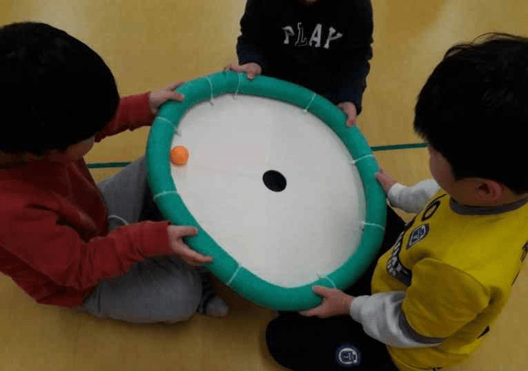 놀이체육 도구를 함께 잡은 아이들